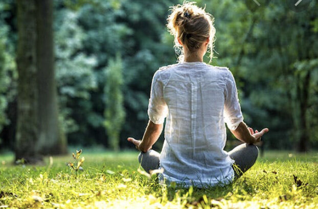 Person meditating in a sunlit forest – promoting mindfulness and mental well-being at Today We Dream