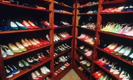 Rows of colorful high-heeled shoes in wooden shelves – reflecting extravagance and historical symbolism.