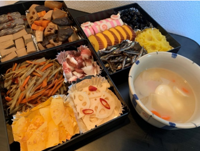 Traditional Japanese New Year’s feast with various symbolic foods and soup, showcasing traditions