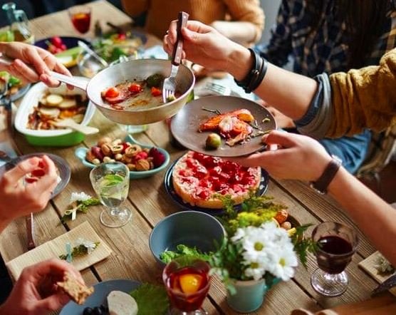 Group of people sharing a meal at a vibrant and cozy table setting, highlighting connection