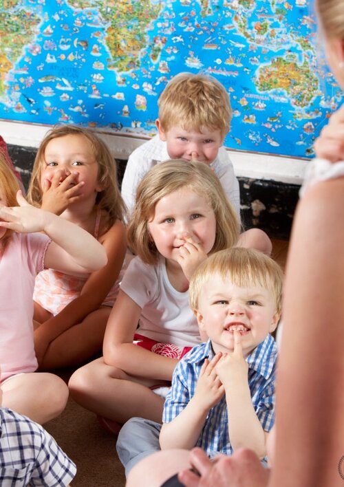 Group of young children interacting with a teacher during class
