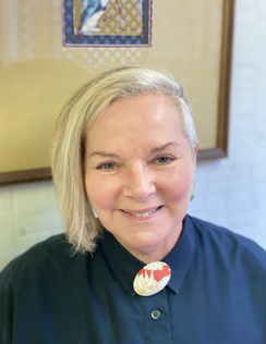 Portrait of a smiling woman, likely an educator or community member